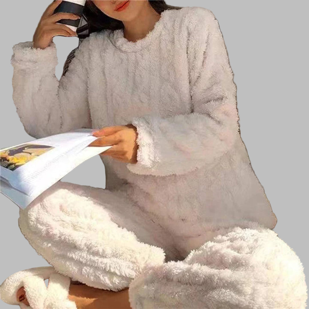 Vrouw in witte, zachte en knusse pyjamaset met mok en tijdschrift. Comfortabele loungewear, perfect voor thuis ontspannen.